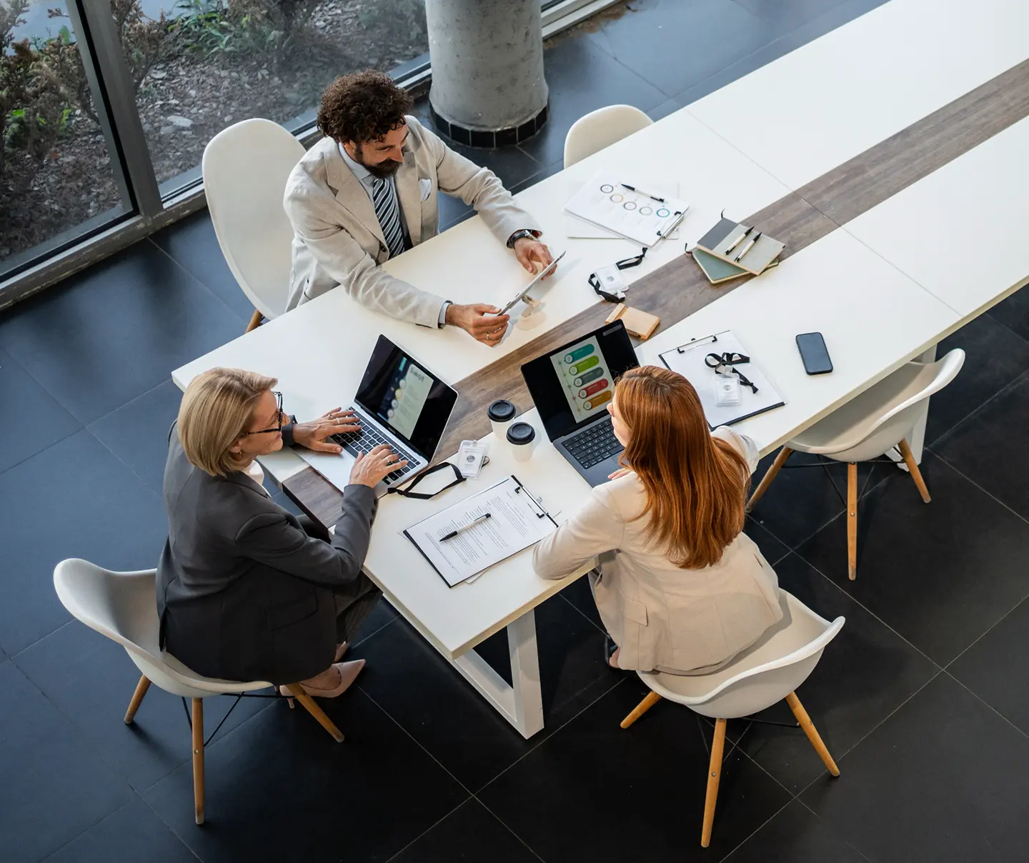 Employees in a meeting and discussing certification details.